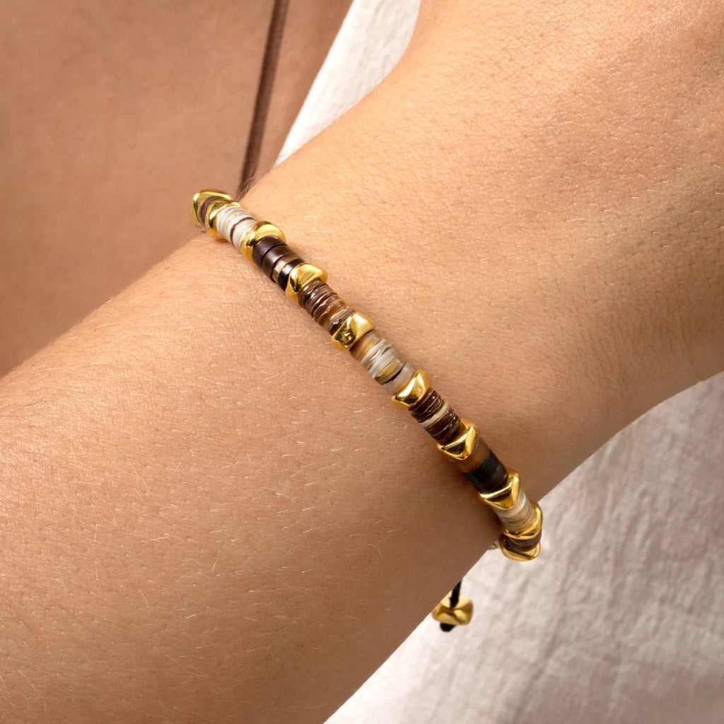 Pulsera ajustable con hilo de seda, conchas filipinas de distintos tonos, con placa con insignia Corso y semillas en baño de oro de 22K - Joyería y bisutería fina